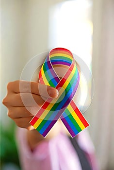 Rainbow Awareness Ribbon Held In Hand Representing Pride And Equality Support
