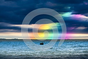 Rainbow back dark cloud on sea. concept god bless, wish