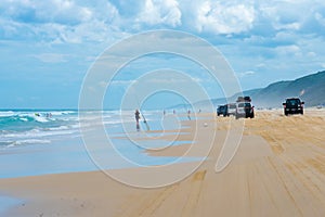 4wd vehicles at Rainbow Beach with coloured sand dunes, QLD, Australia