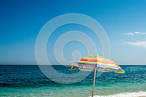 Rainbow beach umbrella on sea background