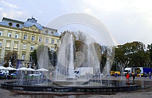 Rainbow in the blue sky over the fountain in the city of Lviv