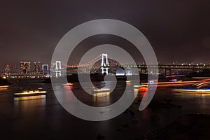 Rainbow bridge at night in Daiba district in Tokyo Japan photo