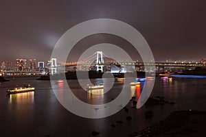 Rainbow bridge at night in Daiba district in Tokyo Japan photo