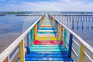 Rainbow bridge in Thailand.View of The colorful wood bridge extends into the sea under blue sky at samut sakhon province,Thailand