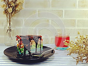 Rainbow cake slice with chocolate sauce