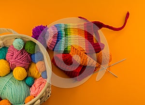 Rainbow cap made of wool on an orange background