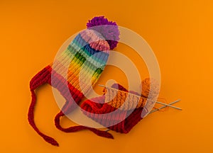 Rainbow cap made of wool on an orange background