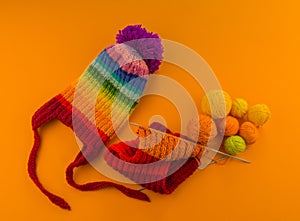 Rainbow cap made of wool on an orange background