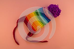 Rainbow cap made of wool on a pink background