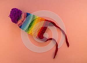 Rainbow cap made of wool on a pink background