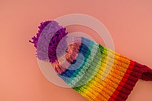 Rainbow cap made of wool on a pink background