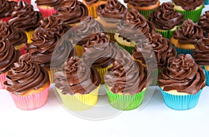 Rainbow of chocolate frosted cupcakes