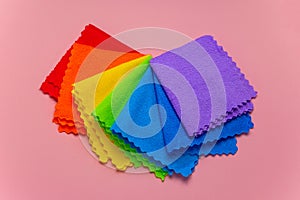 Rainbow cloth patterns isolated on pastel pink background, red, orange, yellow, green, blue and purple rags top view