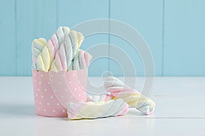 Rainbow color of spiral marshmallows in pink paper cup