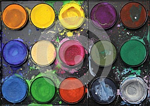 rainbow color watercolor paints palette on black