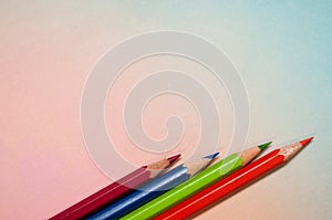 Rainbow colored background with an arrangement of colored pencils photo