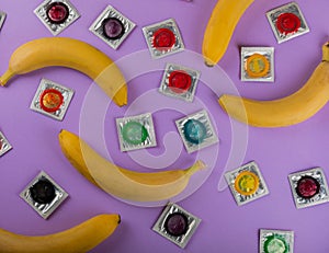 Rainbow of colored condoms on background.