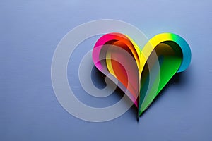 Rainbow colored paper cut out in the love heart shape. Paper art rainbow heart background with 3d effect, heart shape in vibrant