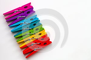 Rainbow colored wooden clothespins on white background with copy space/diversity concept
