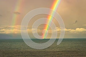 Rainbow colorful above sea horizon at dawn