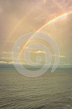 Rainbow colorful above sea horizon at dawn