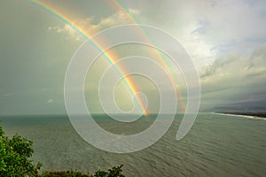 Rainbow colorful above sea horizon at dawn