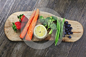 A Rainbow of Colorful, Healthy Fruits and Vegetables are Displayed on a Wooden Cutting Board