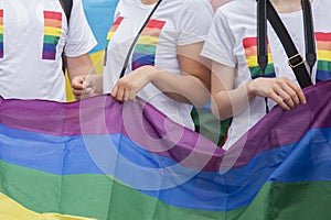 Rainbow colors cloth in hands of GayPride spectators during Pride parade. photo