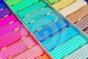 Rainbow colors of modeling clay. Multicolored plasticine bars ina box, background texture