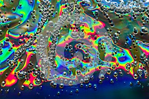 Rainbow colors in oil with silvery frothing bubble surface in abstract background asset