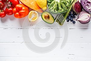 Rainbow colors vegetables and berries on white background, top view. Detox, vegan food, ingredients for juice and salad