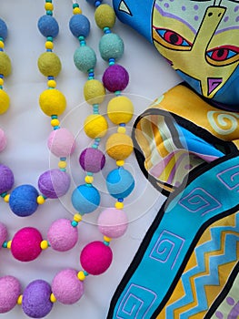 Rainbow colors on wool beads. Felt decoration and silk scarf with a cat.