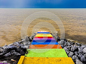 Rainbow colour staircase into the sea