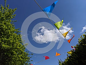 Rainbow coloured bunting flags flying in the sky photo