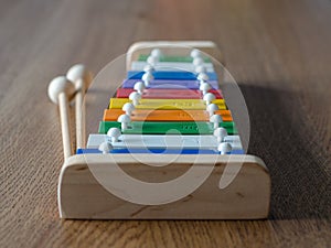 Rainbow coloured xylophone on wooden background angle view. meta