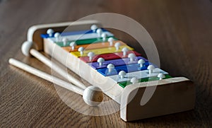 Rainbow coloured xylophone on wooden background angle view. meta