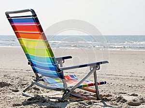 Rainbow colours beach chair on the sand, ocean