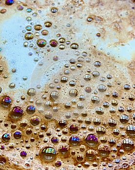 Rainbow of colours in the bubbles on a coffee cup