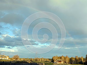 Rainbow in the dark sky above the settlement