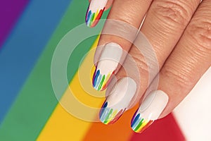 Rainbow design on long oval nails.