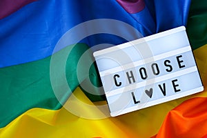 Rainbow flag with lightbox and text CHOOSE LOVE. Rainbow lgbtq flag made from silk material. Symbol of LGBTQ pride month