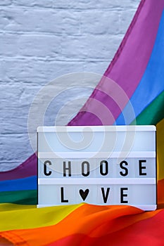 Rainbow flag with lightbox and text CHOOSE LOVE. Rainbow lgbtq flag made from silk material. Symbol of LGBTQ pride month