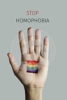 Rainbow flag and text stop homophobia