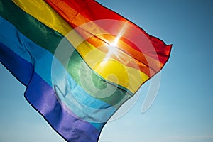 Rainbow flag waving on the blue sky