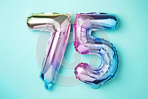 Rainbow foil balloon number, digit seventy-five. Birthday greeting card with inscription 75. Anniversary concept. Top