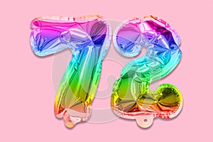 Rainbow foil balloon number, digit seventy two on a pink background. Birthday greeting card with inscription 72.
