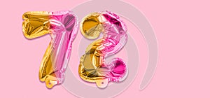 Rainbow foil balloon number, digit seventy two on a pink background. Birthday greeting card with inscription 72.