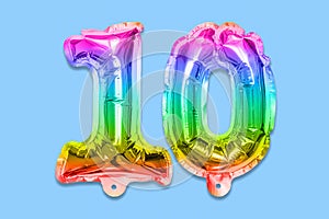 Rainbow foil balloon number, digit ten on a blue background. Birthday greeting card with inscription 10.