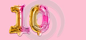 Rainbow foil balloon number, digit ten on a pink background. Birthday greeting card with inscription 10