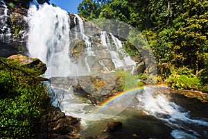 Rainbow in front of a waterfall on a rainy day